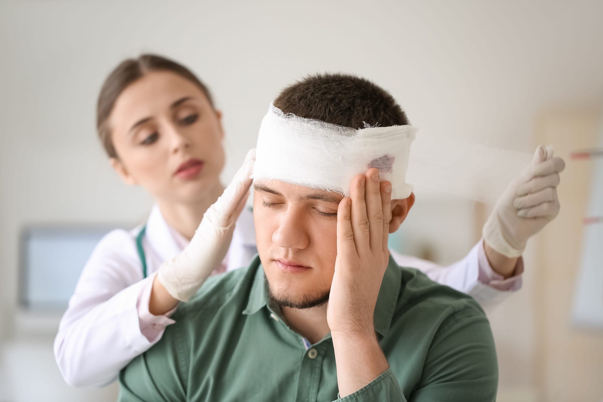 Doctor bandaging the patient's head