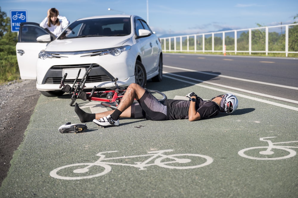 Car Accident Cyclist Has Been Hit By A White Car And Is Laying On The Ground