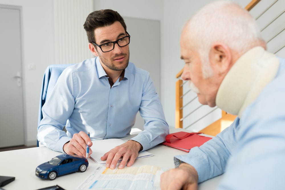 An Injured Older Man Talking With An Insurance Agent