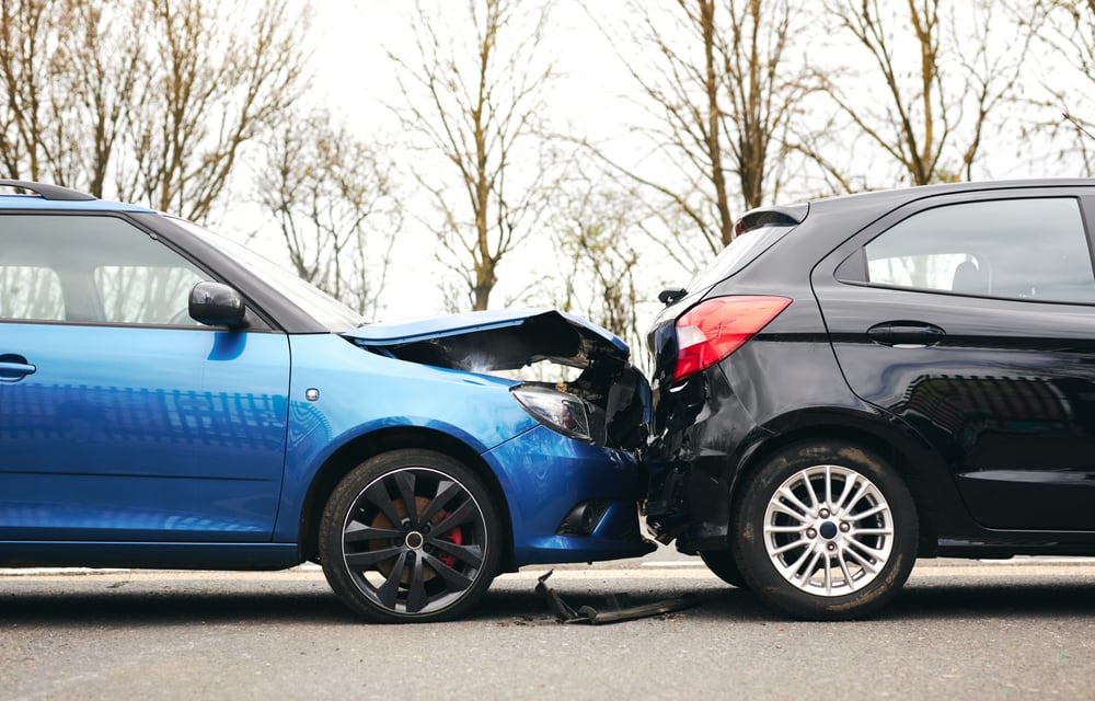 A rear end car accident of a blue and black car