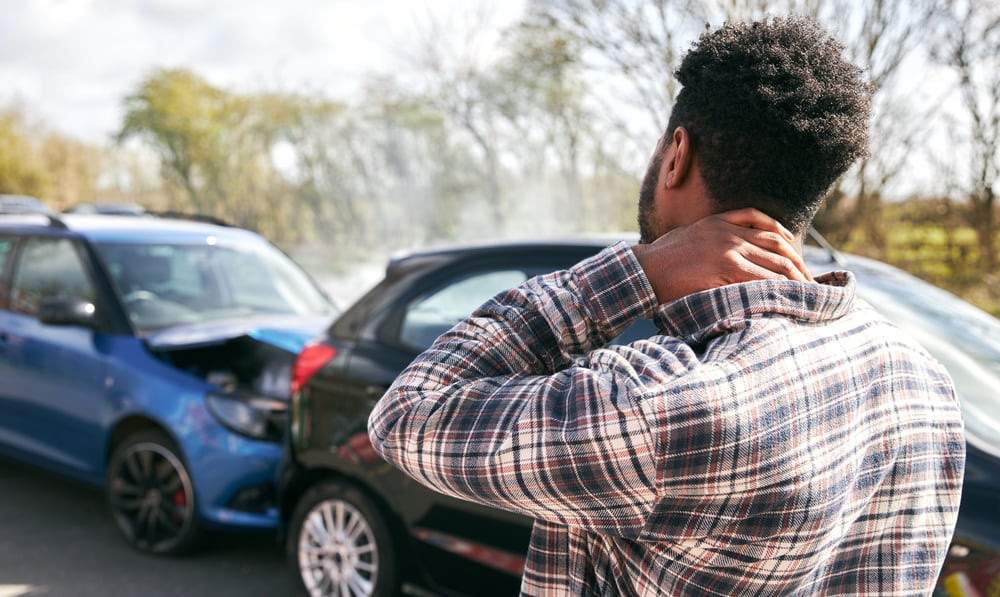 Driver holding his injured neck after getting in a rear end car accident